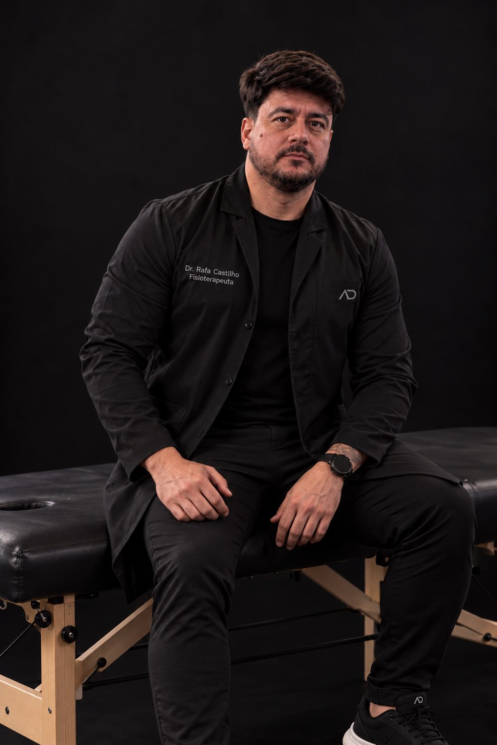 Rafael Castilho, fisioterapeuta da Athletic Development, sentado na maca do consultório